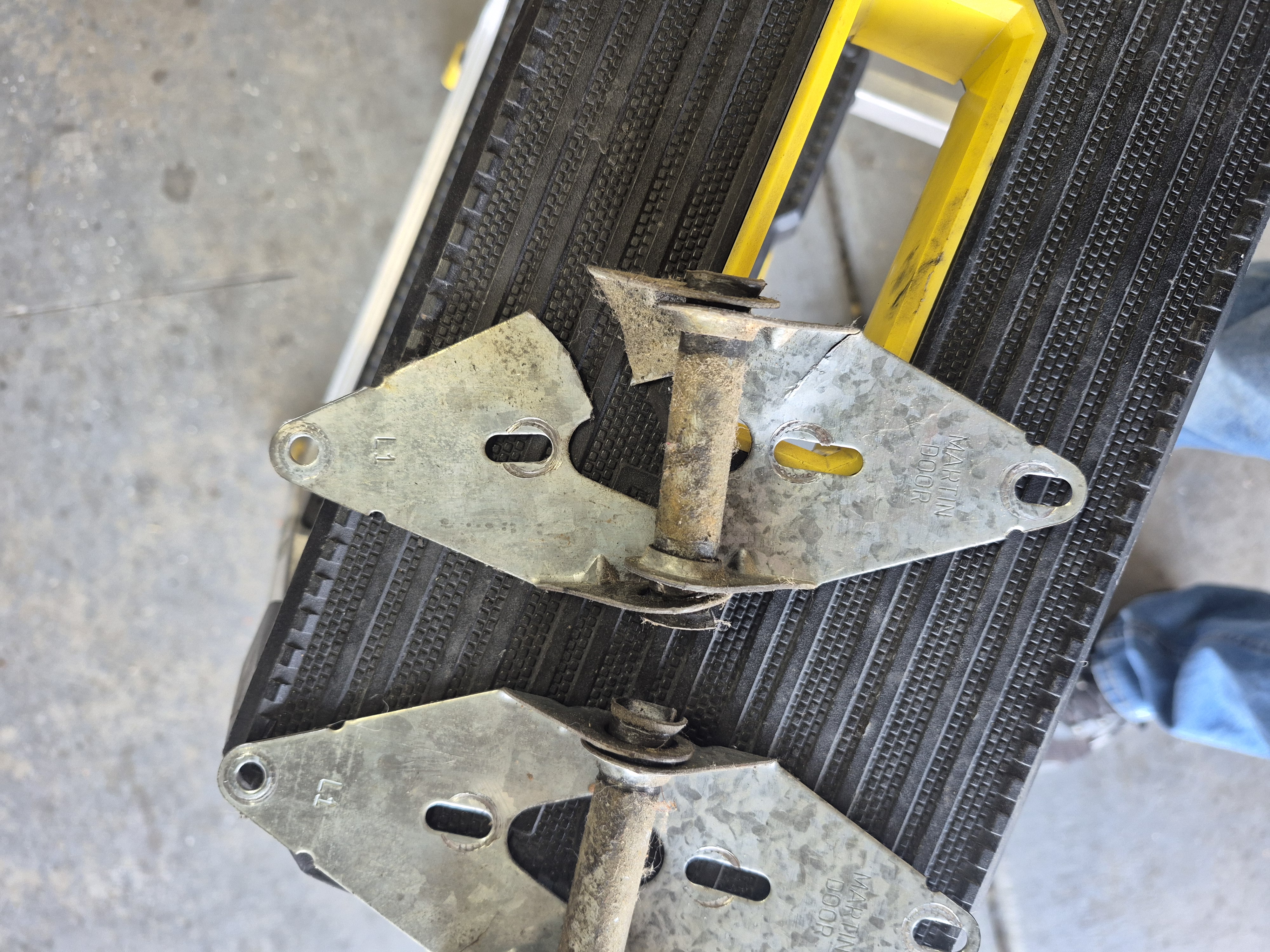 Technician performing a garage door tune-up and lubrication